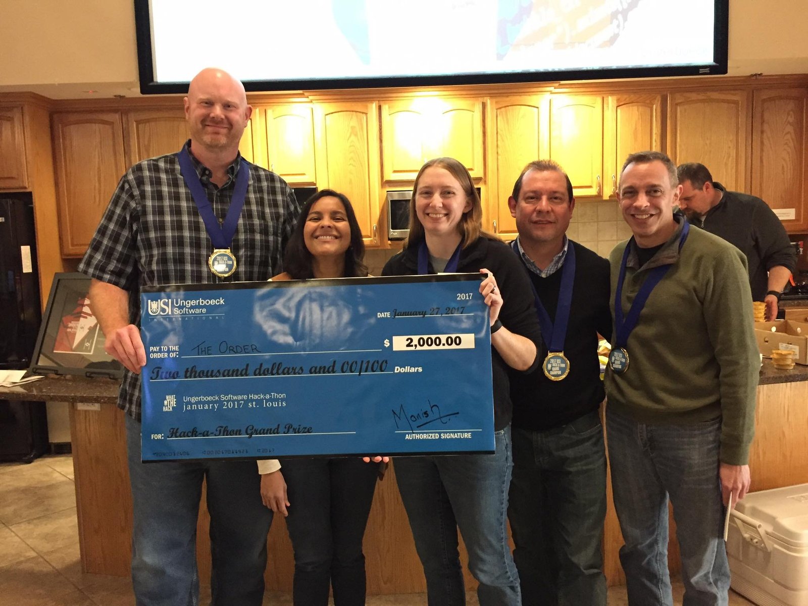 Wayne Lewis, Ronelle Page, Crystal Weaver, Danilo Bernal, and Rob Rebman holding a giant check for winning a Hackathon